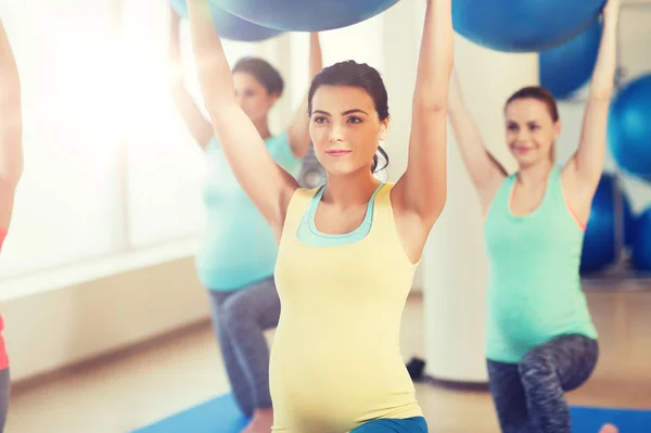 Mujeres embarazadas felices haciendo ejercicio con pelota en el gimnasio —  Fotos de Stock