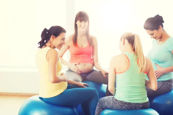 Mutlu hamile kadınlar spor salonunda topların üzerinde otururlar. — Stok fotoğraf