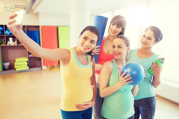 怀孕妇女以智能手机在健身房的自拍照 — 图库照片