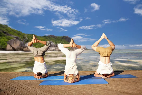 Gente haciendo yoga headstand en la estera al aire libre —  Fotos de Stock