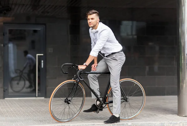 Hombre con bicicleta y auriculares en la calle de la ciudad — Foto de Stock