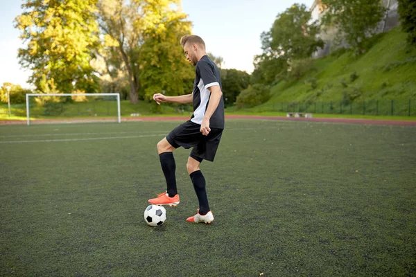 Jugador de fútbol jugando con pelota en el campo de fútbol —  Fotos de Stock