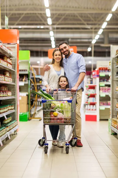 Familia con comida en el carrito de la compra en la tienda de comestibles —  Fotos de Stock