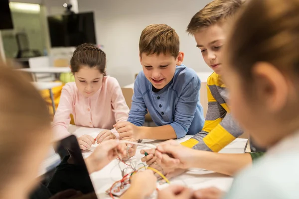 Счастливые дети с набором изобретений в школе робототехники — стоковое фото