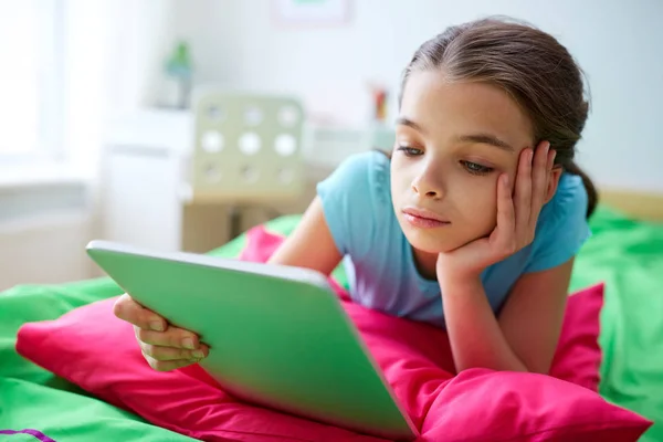 Uśmiechnięte dziewczyny z komputera typu tablet, leżąc w łóżku w domu — Zdjęcie stockowe