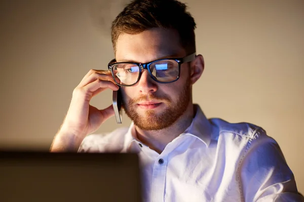 Hombre de negocios llamando en el teléfono inteligente en la oficina de noche —  Fotos de Stock