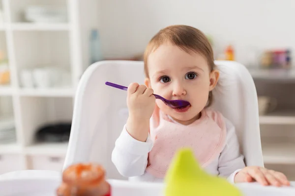 Mädchen mit Löffel isst Püree aus Glas zu Hause — Stockfoto