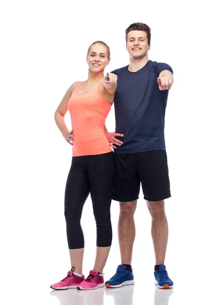 Happy sportive man and woman pointing finger — Stock Photo, Image
