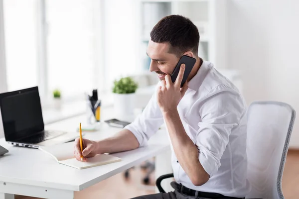 Uomo d'affari che chiama su smartphone in ufficio — Foto Stock