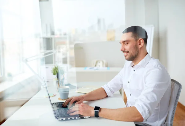 Glad affärsman att skriva på laptop på kontoret — Stockfoto