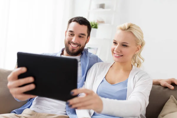 Sonriendo feliz pareja con la tableta PC en casa — Foto de Stock
