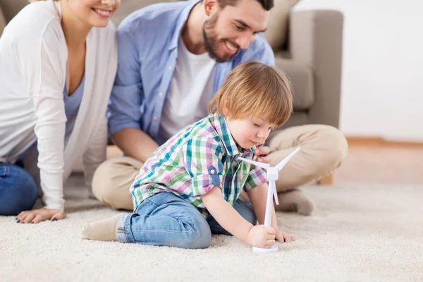 Família feliz brincando com turbina eólica de brinquedo — Fotografia de Stock