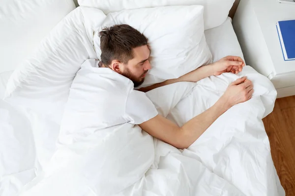 Hombre durmiendo en la cama en casa dormitorio — Foto de Stock