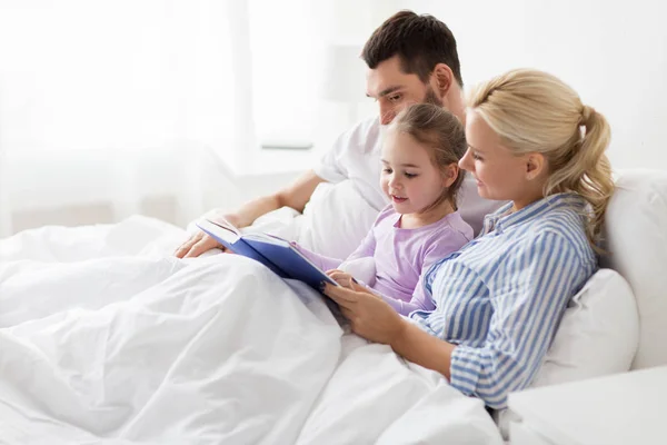 Libro de lectura familiar feliz en la cama en casa — Foto de Stock