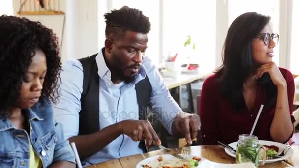 Amigos felizes comer e falar no restaurante — Vídeo de Stock