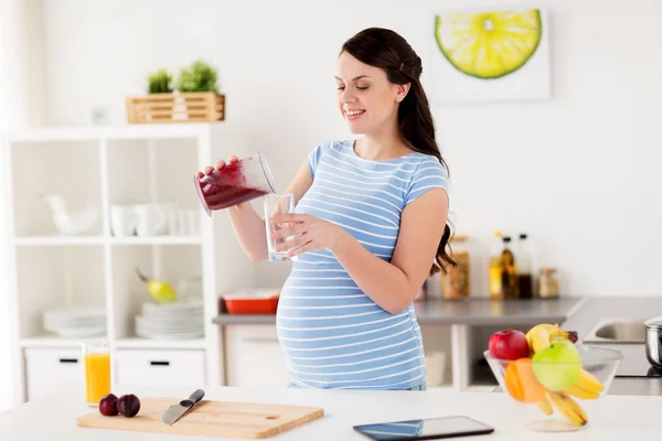 Pregnant woman with blender cup and glass at home — Stock Photo, Image