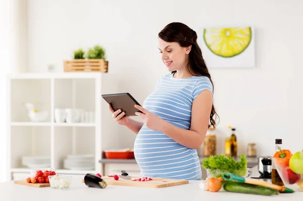 孕妇与平板电脑在家里做饭 — 图库照片
