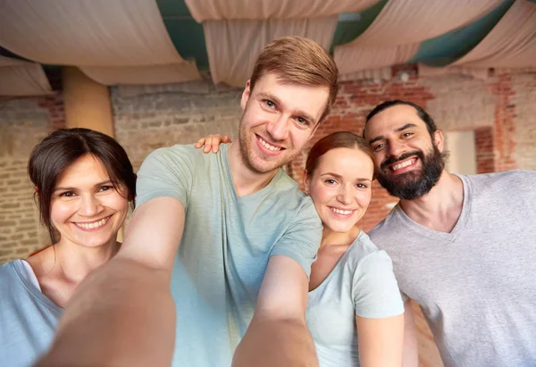 Amigos felizes no estúdio de ioga ou ginásio tomando selfie — Fotografia de Stock