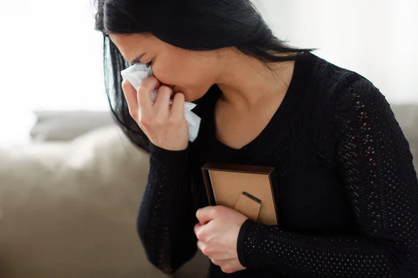Mujer llorando con marco de fotos en el día del funeral — Foto de Stock