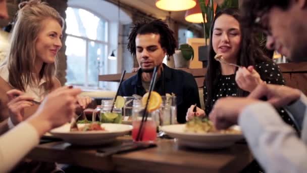 Amigos felices comiendo y bebiendo en el restaurante — Vídeos de Stock