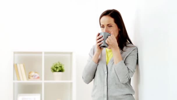 Ευτυχισμένη γυναίκα πίνοντας τσάι ή καφέ στο σπίτι — Αρχείο Βίντεο