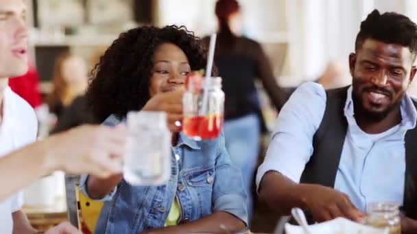 Друзья едят и звонят в стаканы в ресторане — стоковое видео