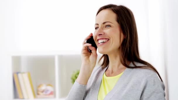 Femme heureuse appelant sur smartphone à la maison — Video