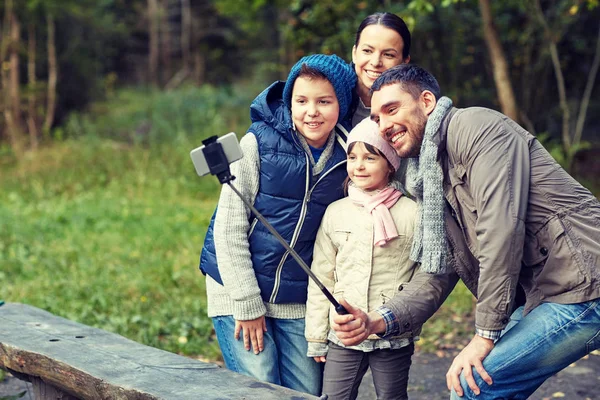 Happy family with smartphone selfie stick at camp — Stock Photo, Image