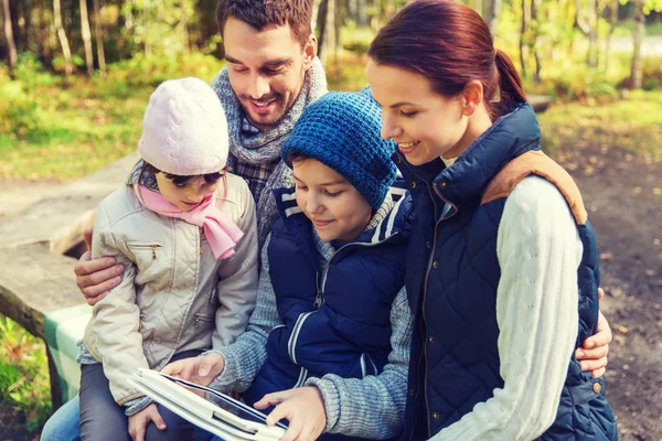 Familia feliz con la tableta PC en el campamento —  Fotos de Stock