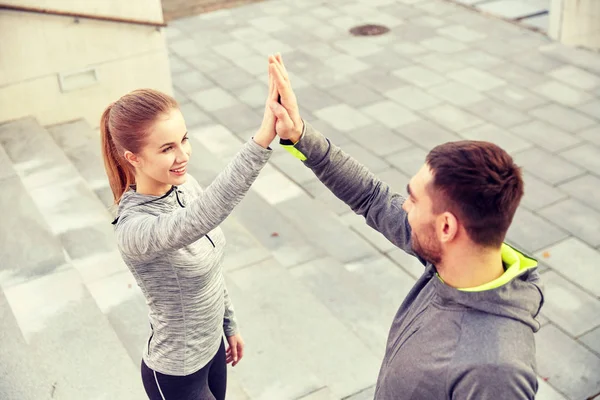 Lächelndes Paar macht High Five auf der Stadtstraße — Stockfoto