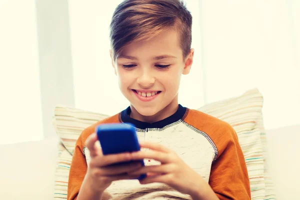 Menino com mensagens de texto smartphone ou jogar em casa — Fotografia de Stock