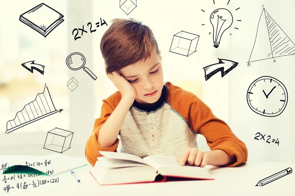 Estudiante niño leyendo libro o libro de texto en casa —  Fotos de Stock