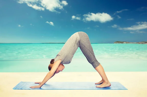 Kvinnan gör hund yogaställning på matta — Stockfoto