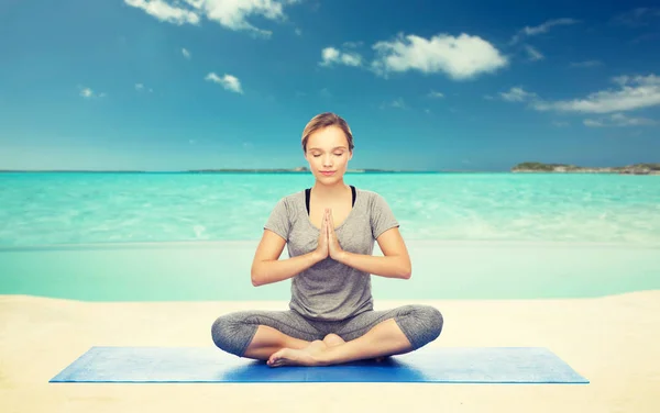 Mulher meditando em pose de ioga de lótus na praia — Fotografia de Stock