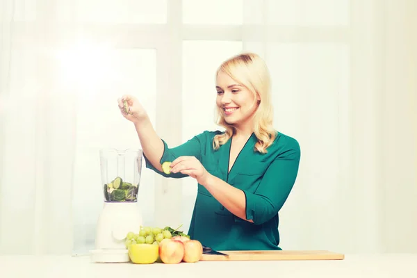 Mujer sonriente con licuadora cocina comida en casa —  Fotos de Stock