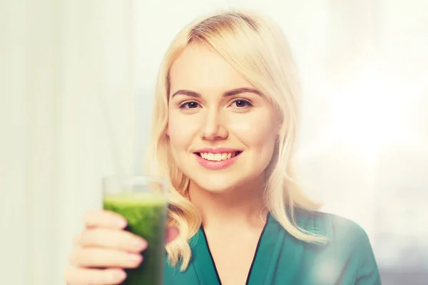 Smiling woman drinking juice or smoothie at home — Stock Photo, Image