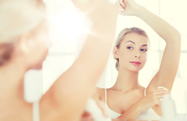 Vrouw met anti-transpirant deodorant op de badkamer — Stockfoto