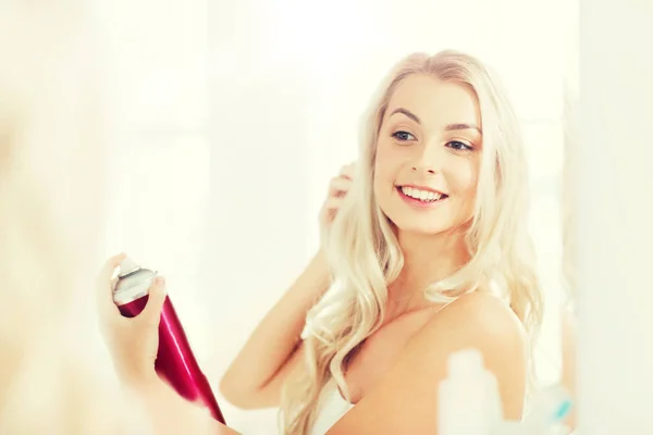 Woman with hairspray styling her hair at bathroom — Stock Photo, Image