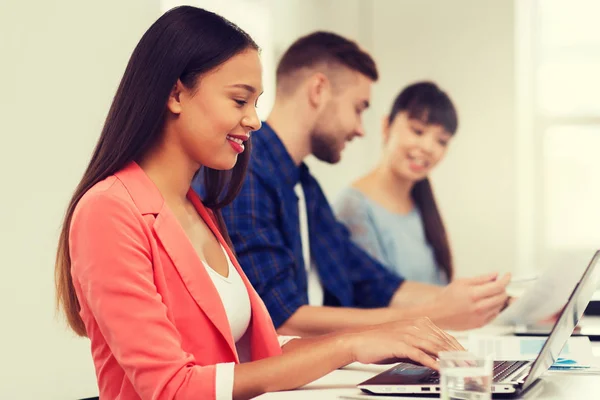 Mujer africana feliz sobre el equipo creativo en la oficina —  Fotos de Stock