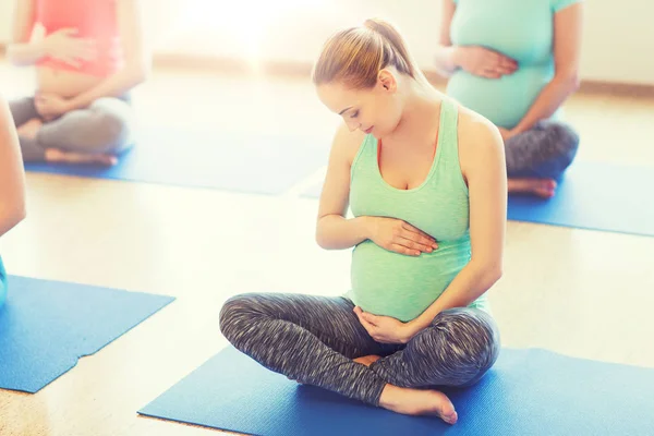Счастливые беременные женщины, занимающиеся йогой в спортзале — стоковое фото