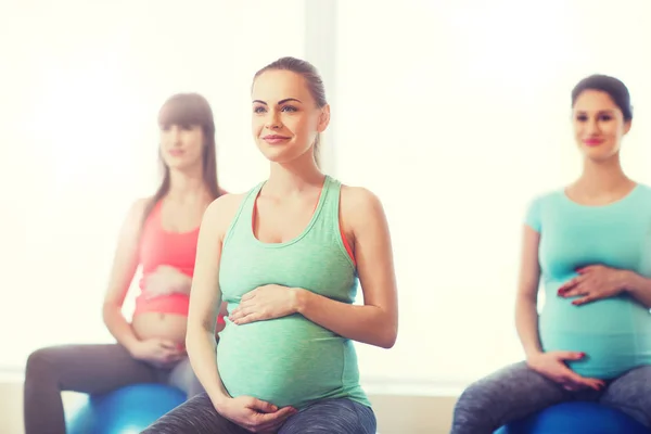Mujeres embarazadas felices haciendo ejercicio en fitball en el gimnasio — Foto de Stock