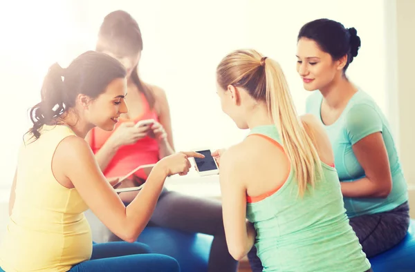 Femmes enceintes heureuses avec des gadgets dans la salle de gym — Photo