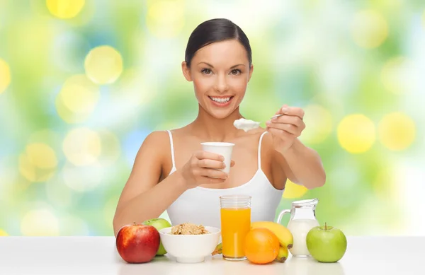 Mulher feliz com frutas, cereais comendo iogurte — Fotografia de Stock