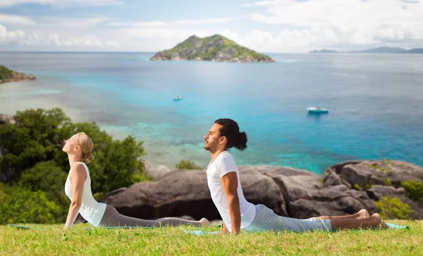 Casal fazendo ioga cobra pose ao ar livre — Fotografia de Stock