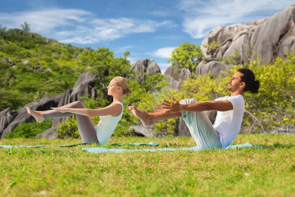 Pareja haciendo yoga media embarcación pose al aire libre —  Fotos de Stock