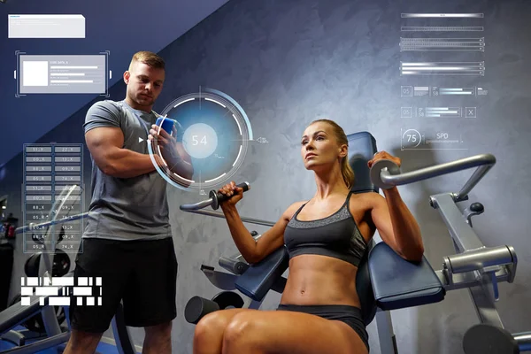 Man and woman flexing muscles on gym machine — Stock Photo, Image