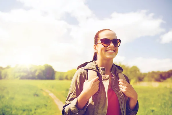 Glad ung kvinna med ryggsäck vandring utomhus — Stockfoto