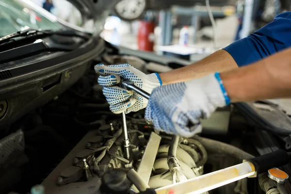 Mechaniker mit Schraubenschlüssel repariert Auto in Werkstatt — Stockfoto