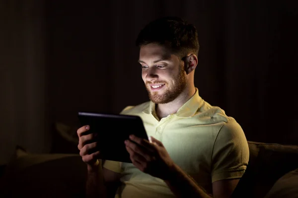 Hombre joven con la tableta ordenador PC por la noche —  Fotos de Stock