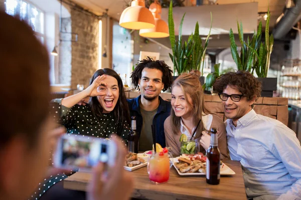 Amigos con smartphone fotografiando en la cafetería — Foto de Stock